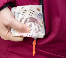 womantakesmoneyczechkorunafinancialconceptfromjacketpocket