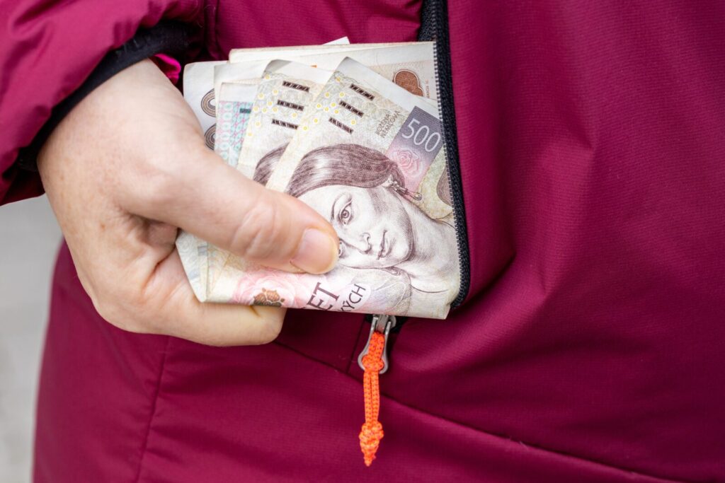 womantakesmoneyczechkorunafinancialconceptfromjacketpocket