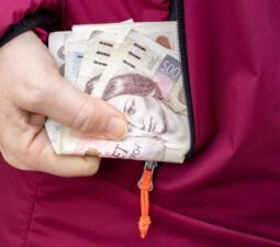 womantakesmoneyczechkorunafinancialconceptfromjacketpocket