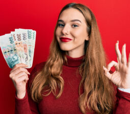 youngblondewomanholdingczechkorunabanknotesdoingoksign