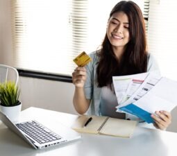 youngwomanholdingcreditcardandbillwithsmilehappily