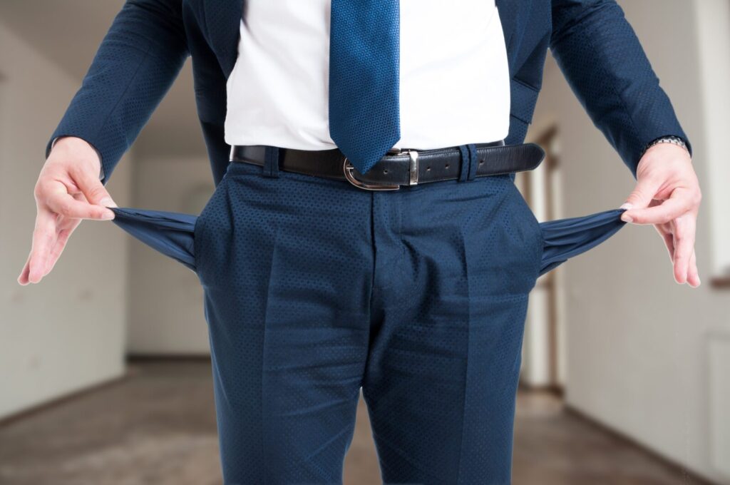 closeupofmalerealtorshowinghisemptysuitpocketsas