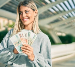 youngblondegirlsmilinghappyholdingczechkorunabanknotesat-2